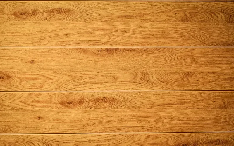Wood plank surface showing oak-style cathedral grain and warm tan-brown tone