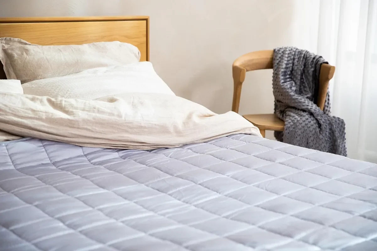Queen mattress on a bed with a wood headboard in a bedroom