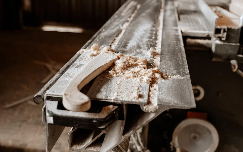 Sawdust buildup on a workshop machine bed after sanding and cutting wood