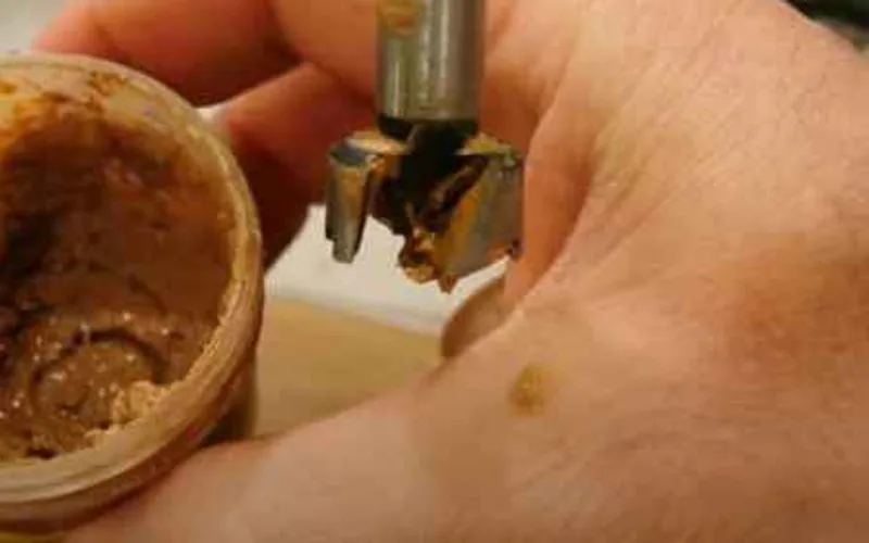 Testing plastic wood filler softness by pressing a metal tool into the tub Testing plastic wood filler softness by pressing a metal tool into the tub