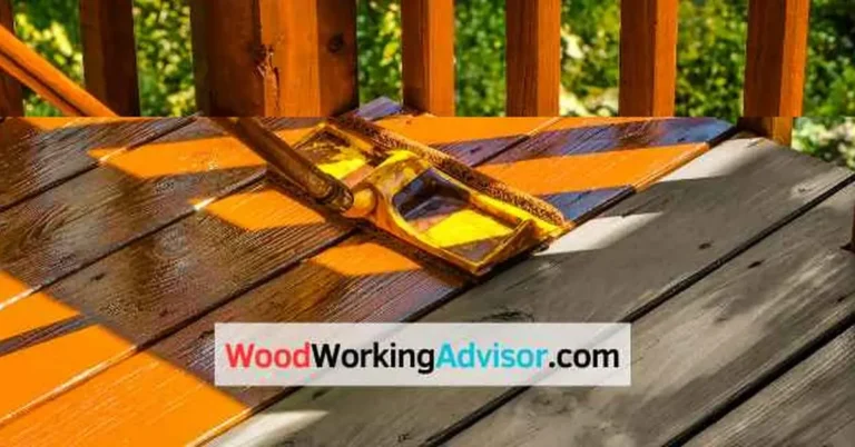 Stripping old deck stain from wood boards with a stain applicator before restaining