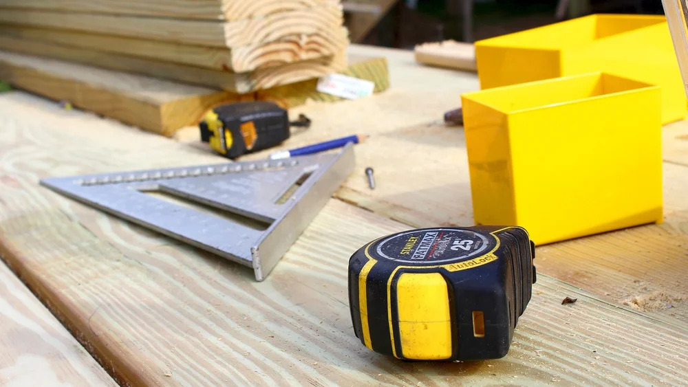 Tape measure and speed square on pine boards ready for marking slats