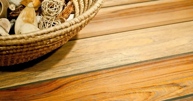 Close-up of golden-brown teak wood grain on a tabletop, showing the color and grain used to identify real teak
