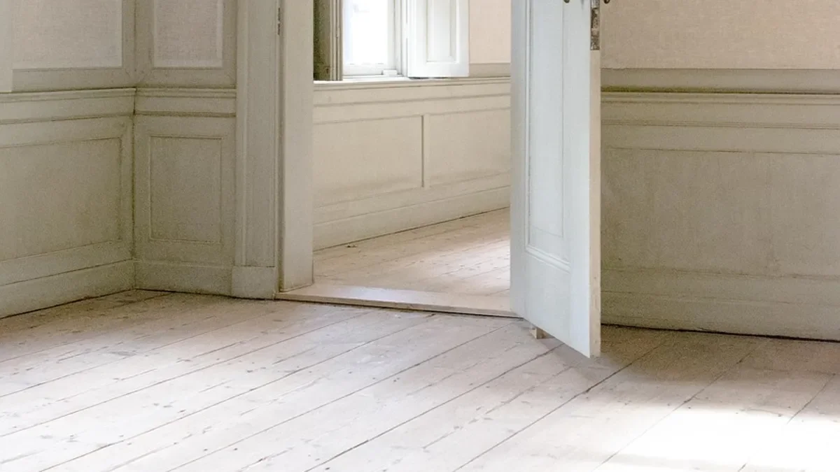 Panelled wainscoting with rails, stiles and a chair rail in a room with a white plank floor