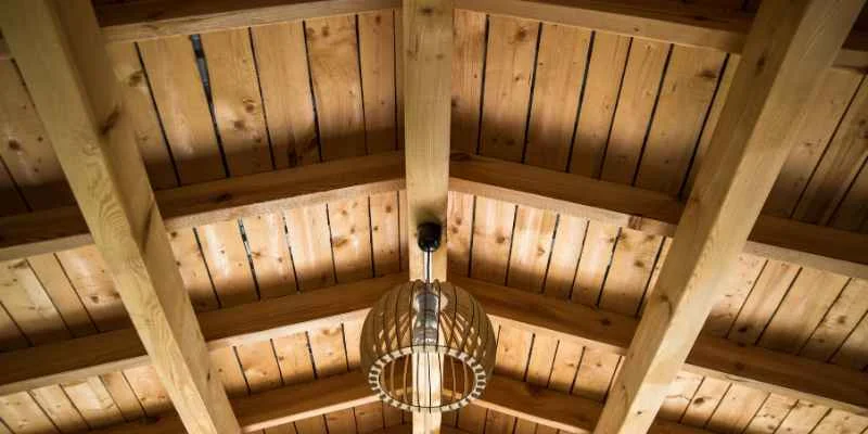 Exposed wood beam and rafter roof structure showing load-bearing framing
