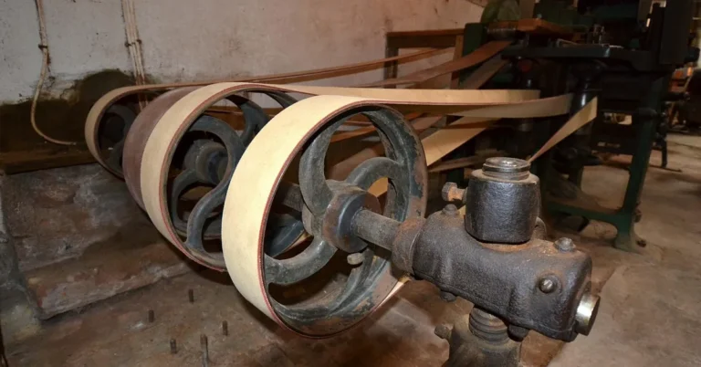 Thin wood veneer sheets wound around the rollers of a veneer splicing machine in a workshop
