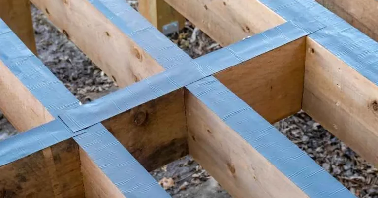 Blue butyl joist tape applied along the tops of wooden deck joists before decking installation