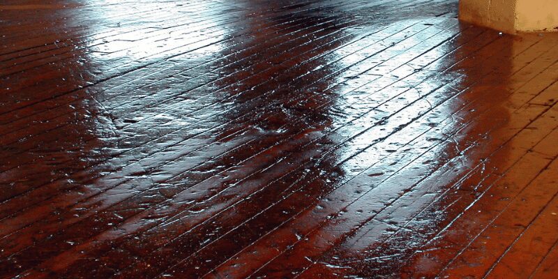 Sealing a restained hardwood floor spot Applying polyurethane sealant with a roller after restaining a hardwood floor spot