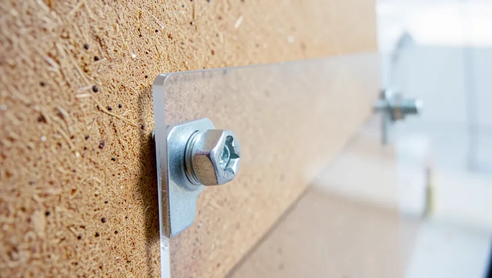 Acrylic standoffs mounting a plexiglass panel to a wood backing board