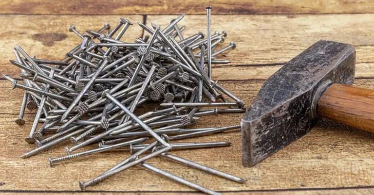 Metal fasteners and a hammer on wood, the hardware used to attach a metal rod to wood