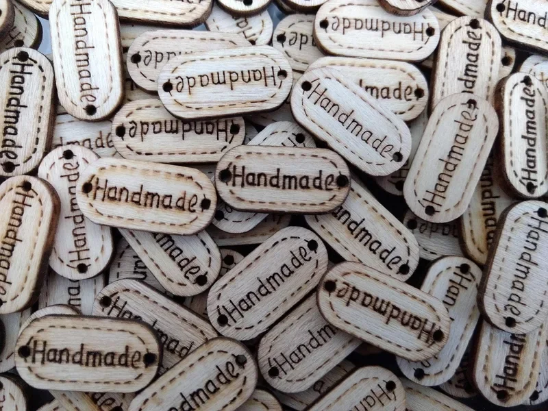 Small wooden tags with a burned handmade mark, one way to label finished pieces