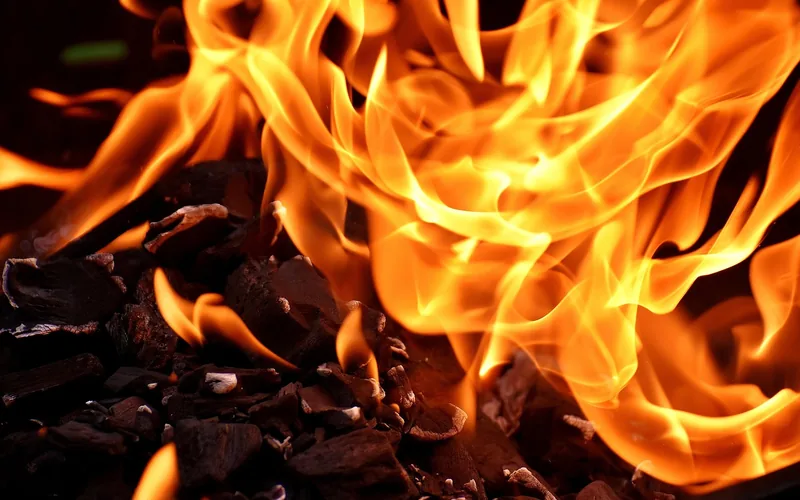 close-up of glowing embers and open flame from an outdoor wood fire close-up of glowing embers and open flame from an outdoor wood fire