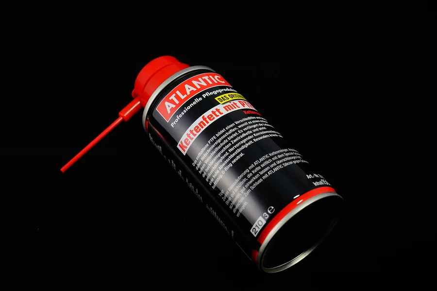 A can of chain and bar lubricant with an applicator spout