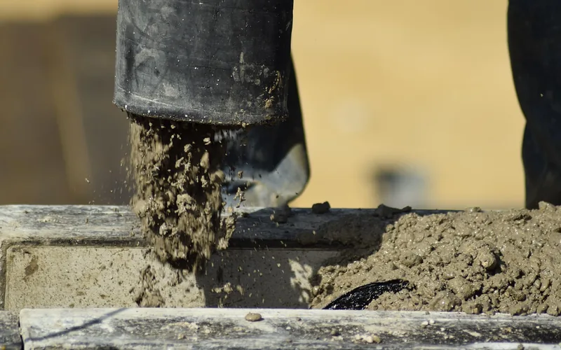 Ready-mix concrete being poured into a foundation form at a construction site