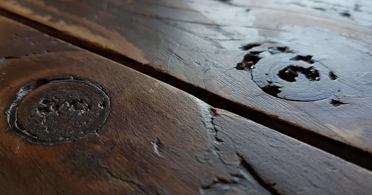 Dark brown stained wood boards with knots