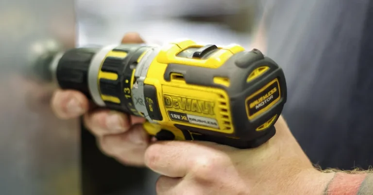 Hand holding a cordless DeWalt drill while drilling