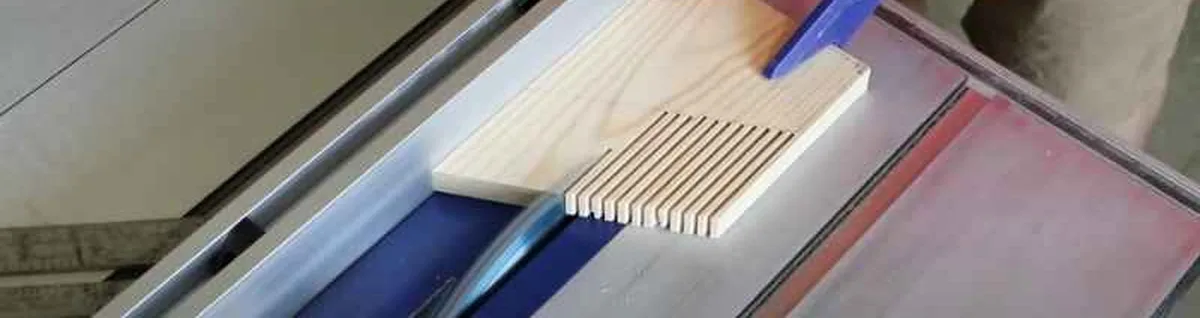 DIY featherboard fingers pressed against a workpiece on a table saw fence