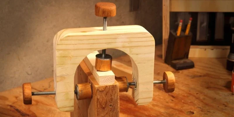 A finished wooden C-clamp with a threaded rod screw mechanism