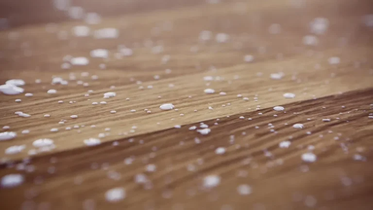 white glue drops beaded on a wood surface