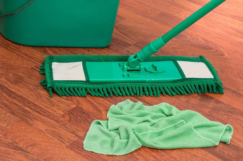 flat microfiber mop and cloth resting on a wood floor