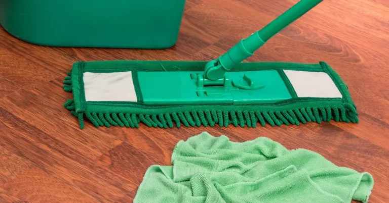 Flat microfiber mop and cloth resting on a hardwood floor