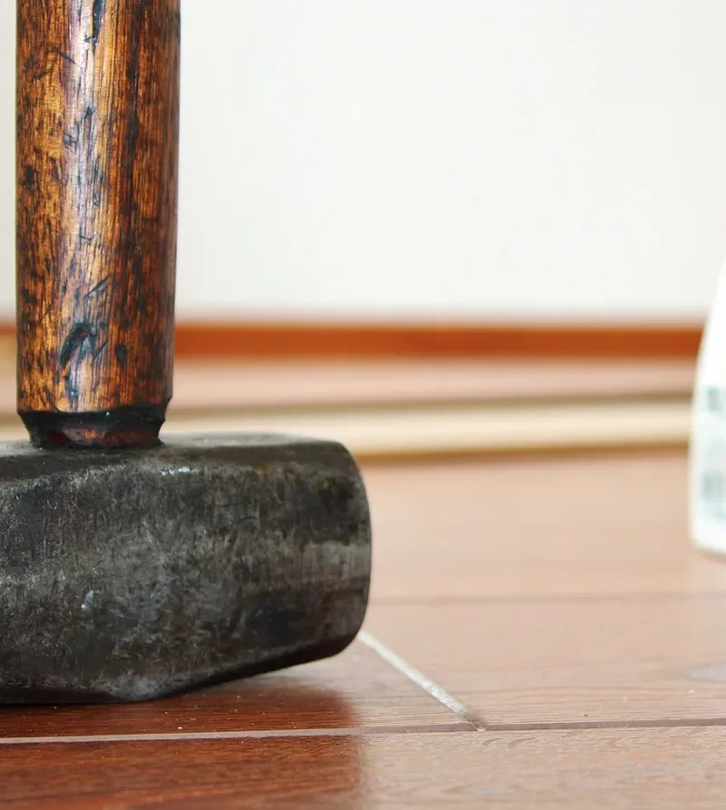 Wood mallet and PVA glue bottle used in wood flooring installation