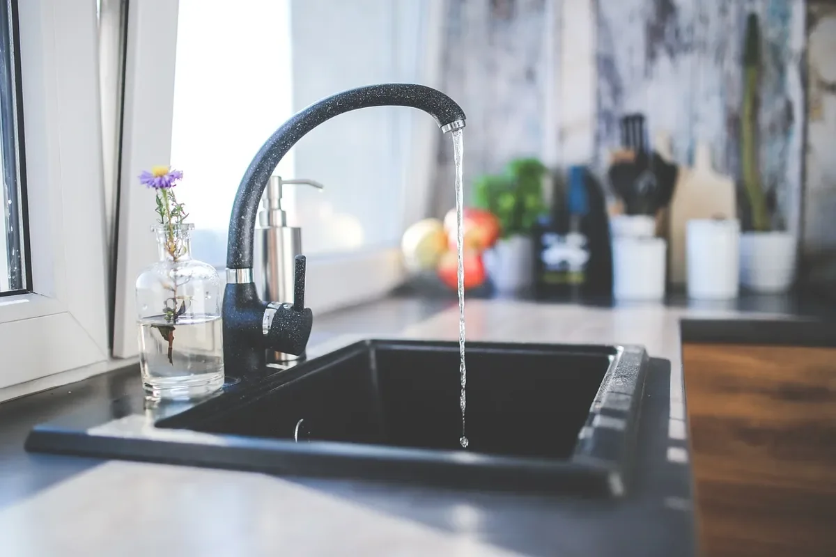 Faucet running into a kitchen sink beside a countertop