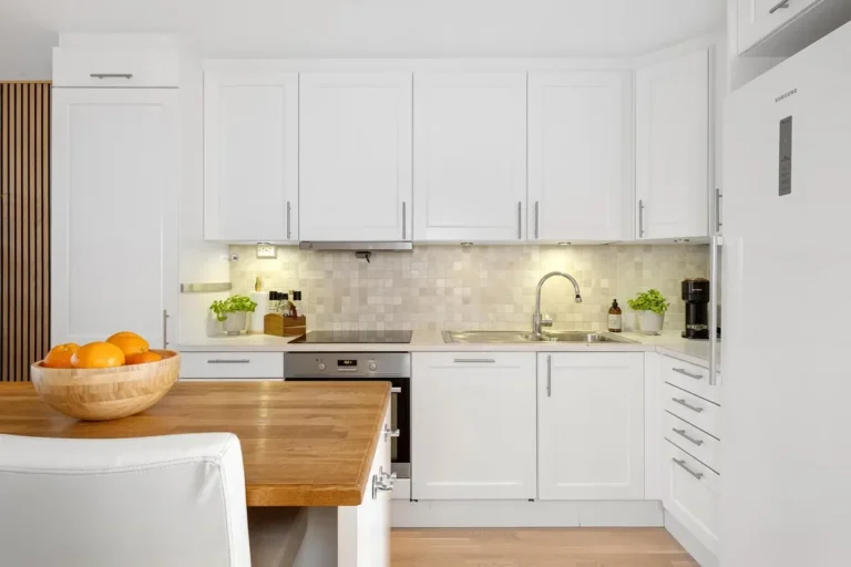 White melamine kitchen cabinets around a sink and cooktop