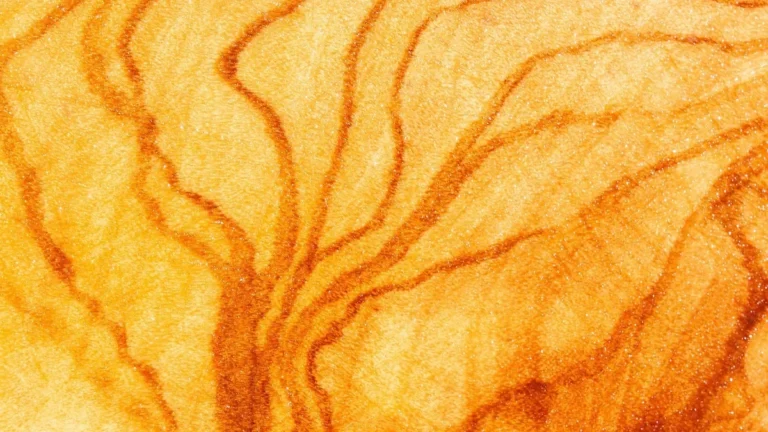 Close-up of oiled olive wood grain with dark orange figure lines