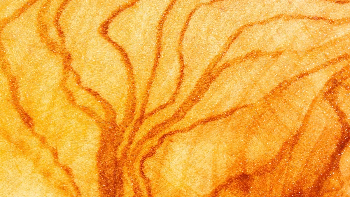 Close-up of oiled olive wood grain with dark orange figure lines