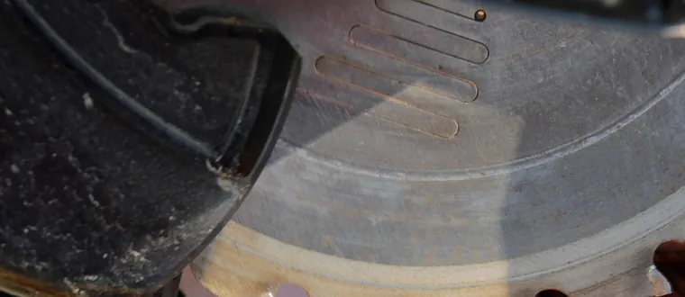 Dusty miter saw blade guard and blade close up