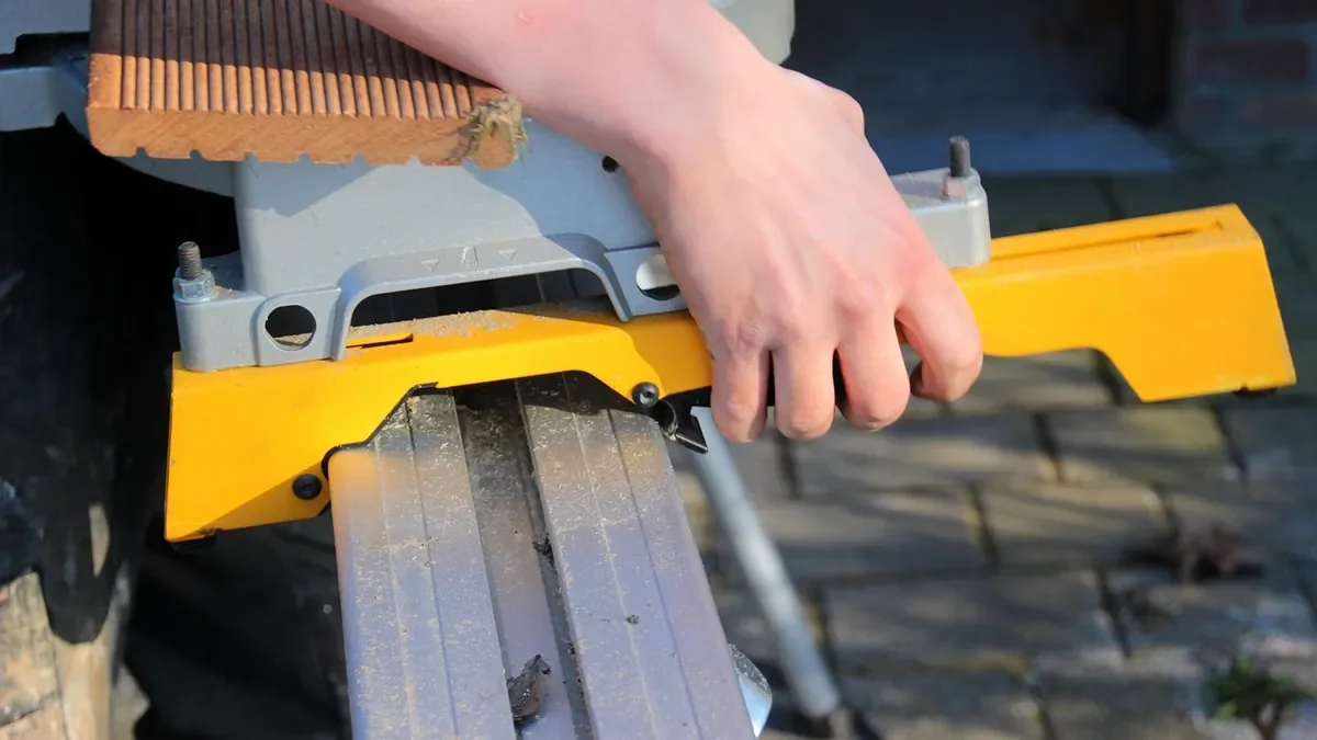 Miter saw with a fold-out support arm holding a board level with the saw table