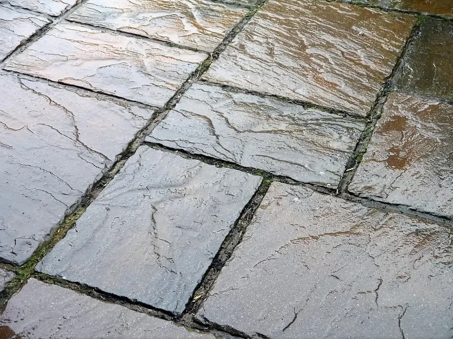 Natural slate pavers showing the uneven cleft surface that affects adhesive coverage