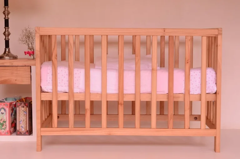 Natural solid wood baby cot with pale pink mattress