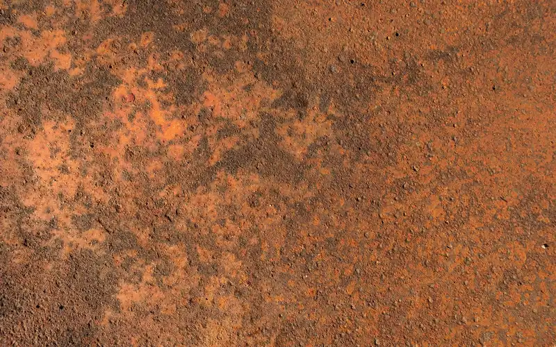 Heavily rusted and pitted metal surface showing surface corrosion damage Heavily rusted and pitted metal surface showing surface corrosion damage