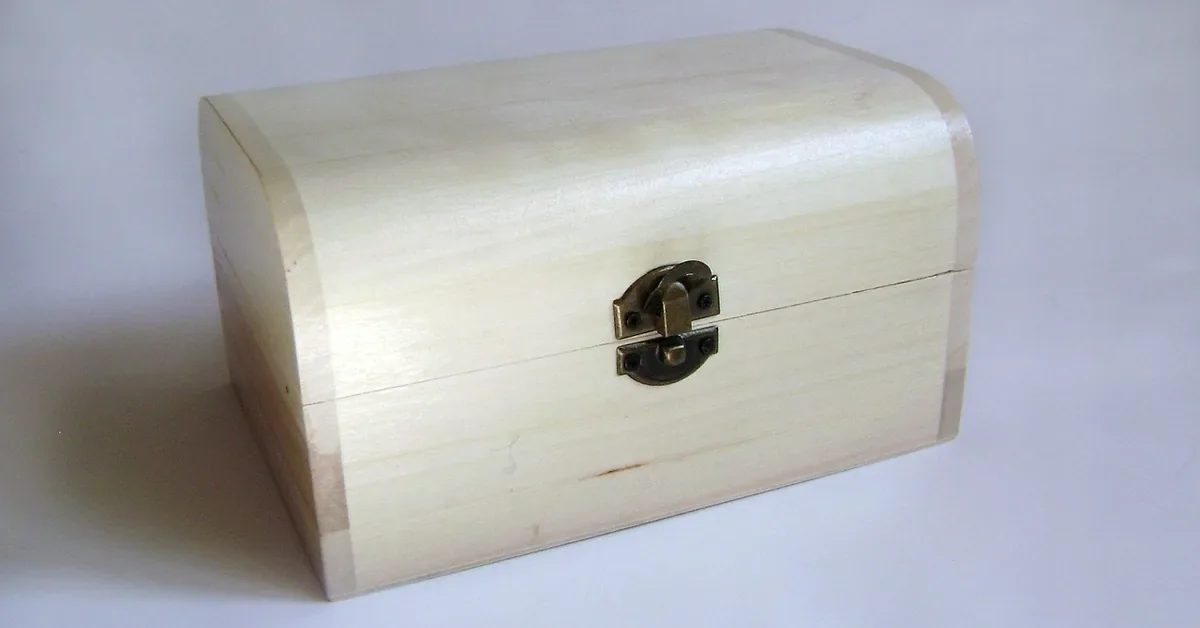 Plain unfinished wooden box with a small brass clasp, the kind of simple box shape a handmade wooden urn is built from