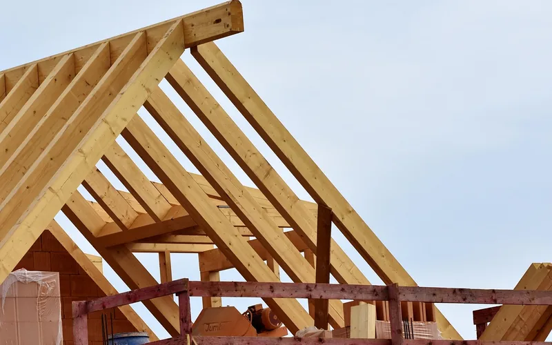 carpenter installing plywood roof sheathing panels on a new home construction site