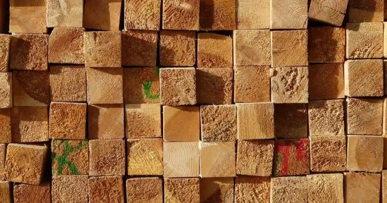 Stack of pressure-treated lumber end grain showing green grade-stamp ink, no arsenic-based CCA preservative used since 2003