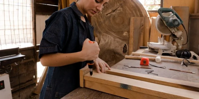 Woodworker using a Japanese pull saw to cut a board