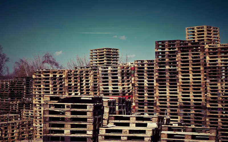 Wooden pallets stacked outdoors, the kind used to elevate lumber off the ground