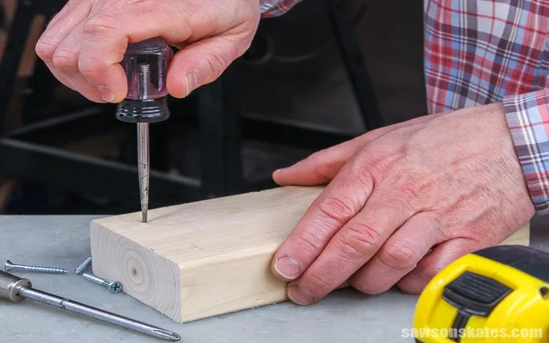 Scratch awl marking a precise line on a wood board before cutting