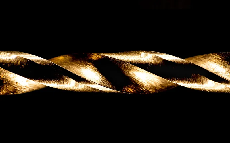 Close-up of a spiral-flute screw extractor bit showing the reverse-thread groove Close-up of a spiral-flute screw extractor bit showing the reverse-thread groove