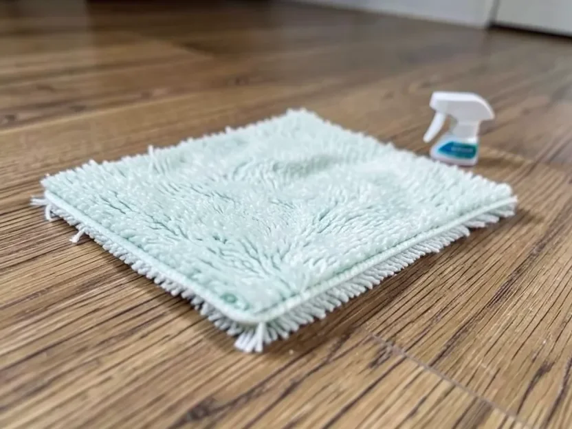 Close-up of a damp microfiber mop cleaning a laminate wood-look floor