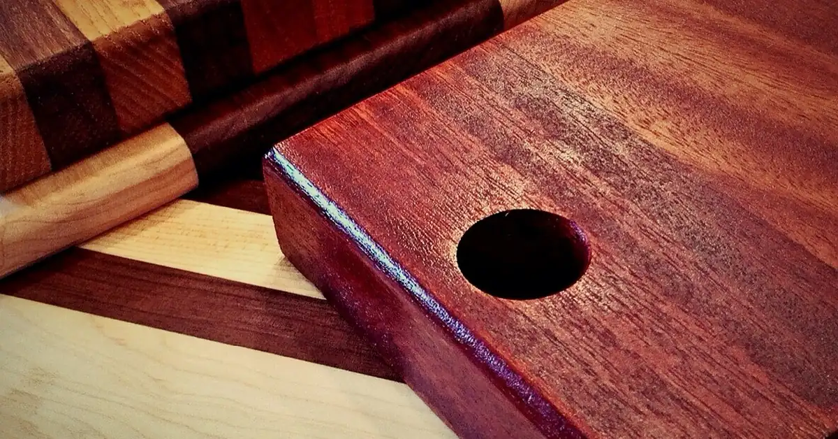 Stack of oiled hardwood cutting boards in walnut, maple and mahogany
