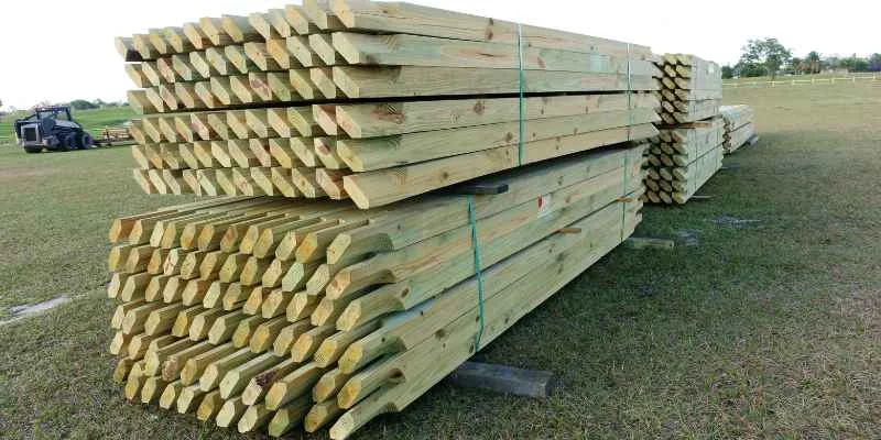 Stacked pressure-treated lumber stakes outdoors