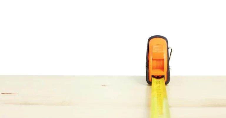 tape measure stretched across a wooden board to check length before cutting