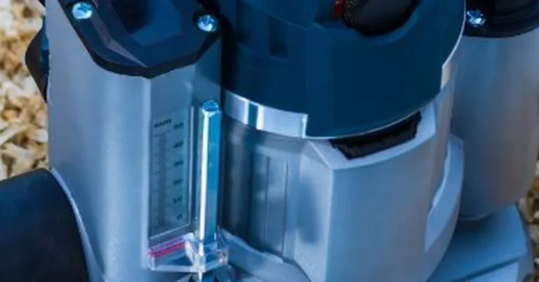 Close-up of a plunge router depth adjustment scale sitting in wood shavings