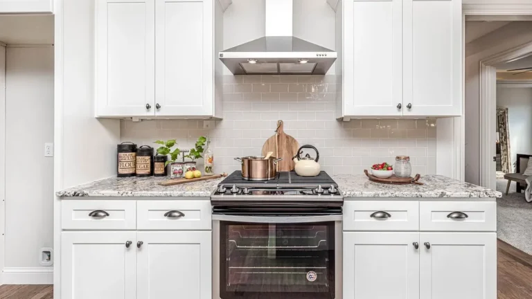 White kitchen with a subway tile backsplash between the counter and wall cabinets