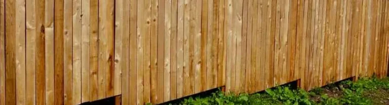Cedar wood fence panels following the slope of uneven backyard ground