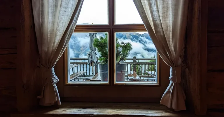 Wood-framed divided-light window in a timber room